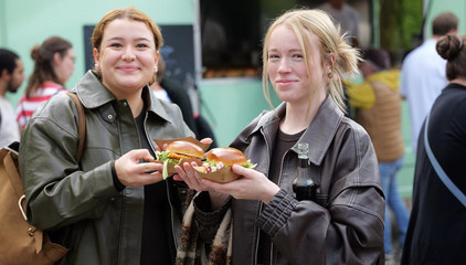 Zwei Besucherinnen mit frischen Burgern in den Händen blicken in die Kamera beim Albertinen-Sommerfest für die Mitarbeitenden aus den unterschiedlichen Einrichtungen der Immanuel Albertinen Diakonie am Standort Schnelsen auf dem Platz vor der Kirche am Albertinen Krankenhaus. Zwei Besucherinnen mit frischen Burgern in den Händen blicken in die Kamera beim Albertinen-Sommerfest für die Mitarbeitenden aus den unterschiedlichen Einrichtungen der Immanuel Albertinen Diakonie am Standort Schnelsen auf dem Platz vor der Kirche am Albertinen Krankenhaus.