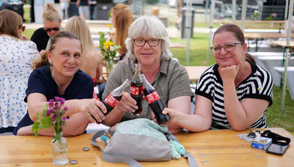 Drei Mitarbeiterinnen sitzen an einem Tisch und stoßen mit Colaflaschen an beim Sommerfest 2026 auf dem Gesundheitscampus Volksdorf des Evangelischen Amalie Sieveking Krankenhauses, der Residenz am Wiesenkamp, des Feierabendhauses Volksdorf und der Albertinen Kindertagesstätte Volksdorf. Drei Mitarbeiterinnen sitzen an einem Tisch und stoßen mit Colaflaschen an beim Sommerfest 2026 auf dem Gesundheitscampus Volksdorf des Evangelischen Amalie Sieveking Krankenhauses, der Residenz am Wiesenkamp, des Feierabendhauses Volksdorf und der Albertinen Kindertagesstätte Volksdorf.