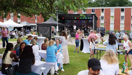 Menschen sitzen draußen auf dem Außengelände mit Tischen, Sitzbänken, Zelten und Musikbühne beim Sommerfest 2026 auf dem Gesundheitscampus Volksdorf vom Evangelischen Amalie Sieveking Krankenhaus, Residenz am Wiesenkamp, Feierabendhaus Volksdorf und Albertinen Kindertagesstätte Volksdorf. Menschen sitzen draußen auf dem Außengelände mit Tischen, Sitzbänken, Zelten und Musikbühne beim Sommerfest 2026 auf dem Gesundheitscampus Volksdorf vom Evangelischen Amalie Sieveking Krankenhaus, Residenz am Wiesenkamp, Feierabendhaus Volksdorf und Albertinen Kindertagesstätte Volksdorf.